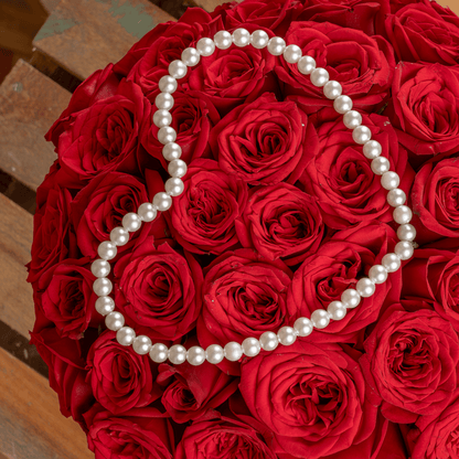 Heart-shaped flower box with 35 fresh red roses, pearl arrangement, and red ribbons.