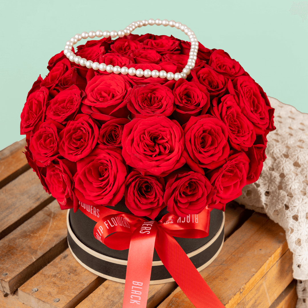 Heart-shaped flower box with 35 fresh red roses, pearl arrangement, and red ribbons.