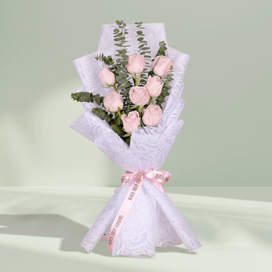 Bouquet of 8 pink roses with eucalyptus wrapped in non-woven paper.