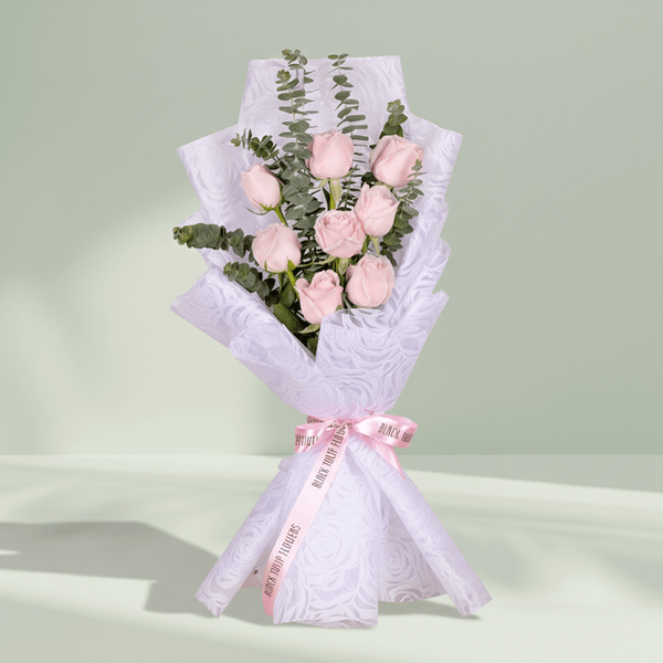 Bouquet of 8 pink roses with eucalyptus wrapped in non-woven paper.