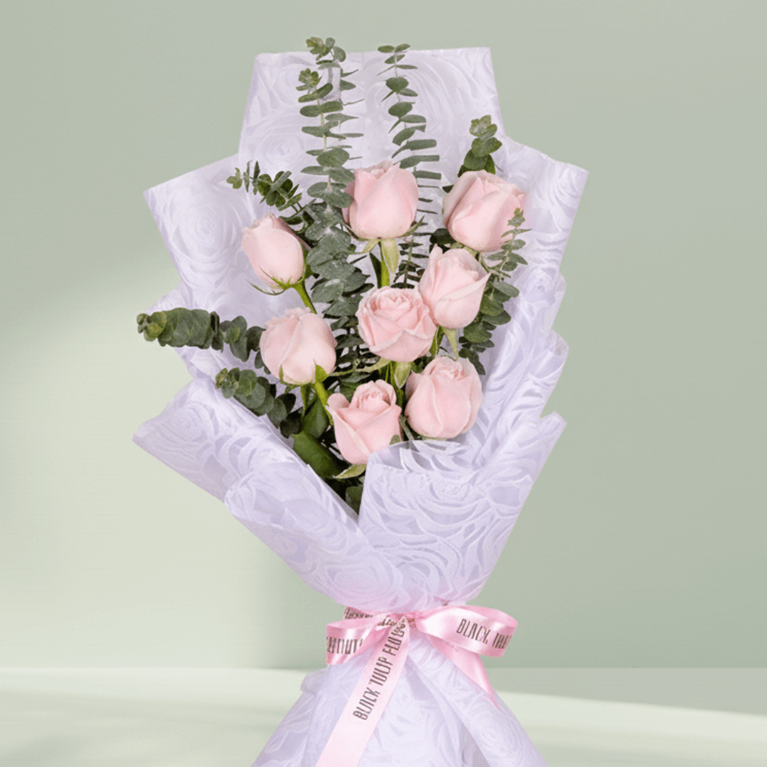 Bouquet of 8 pink roses with eucalyptus wrapped in non-woven paper.