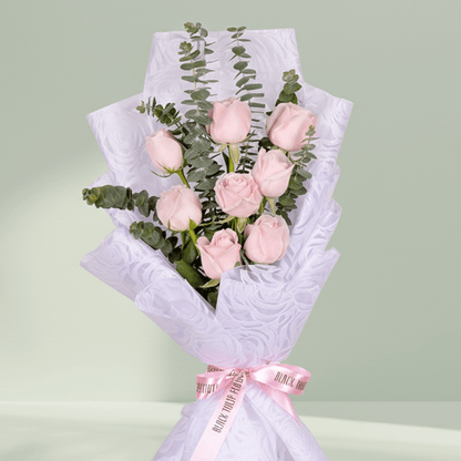 Bouquet of 8 pink roses with eucalyptus wrapped in non-woven paper.