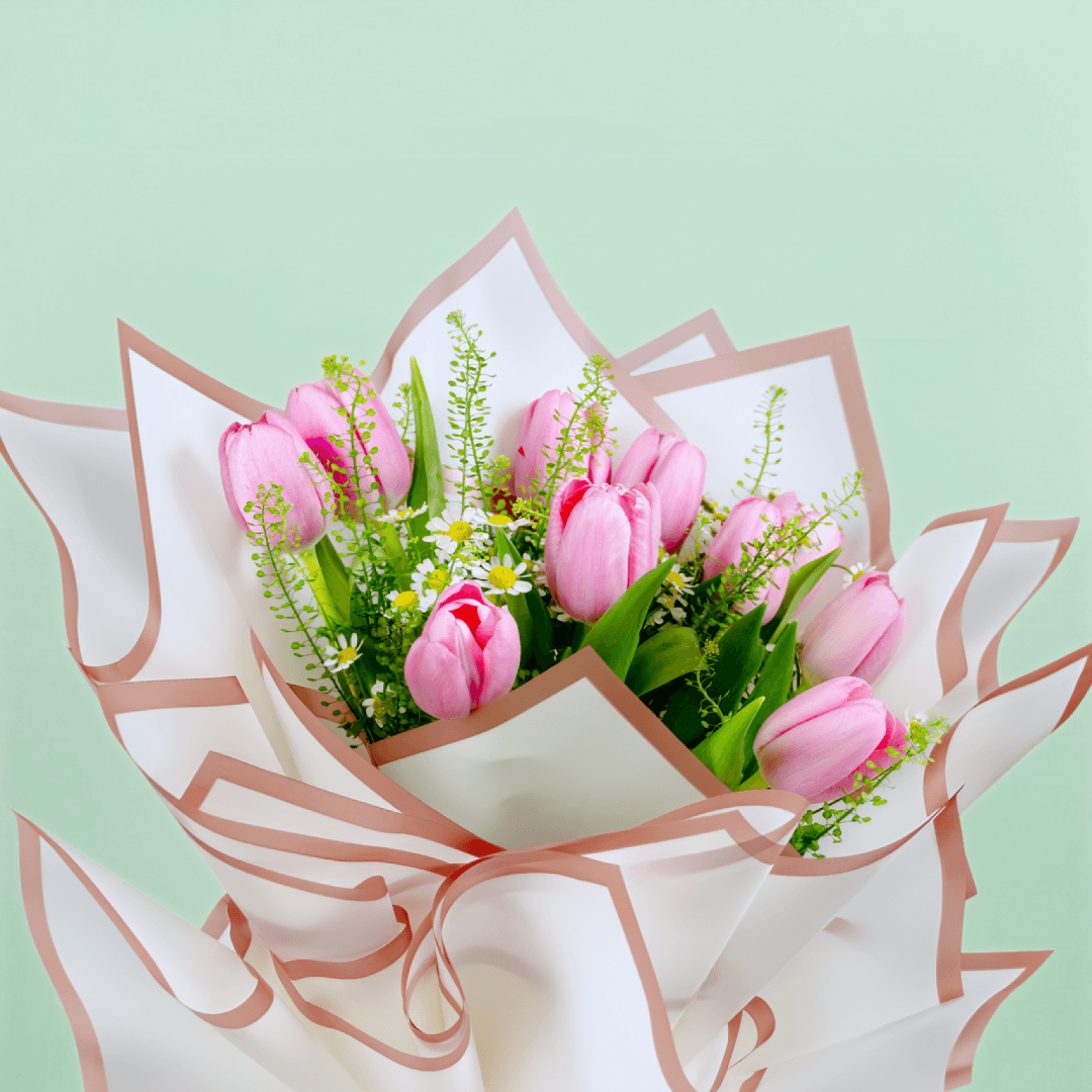 Pink tulips bouquets with green fillers in a white wrap.