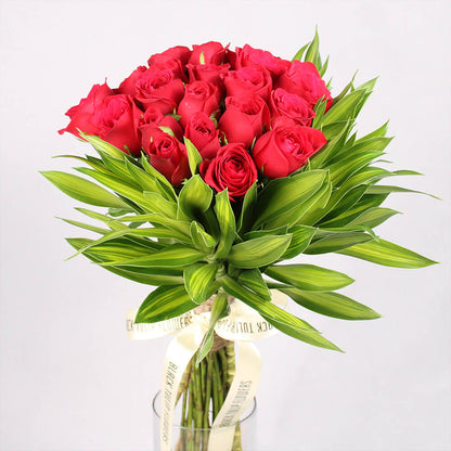 Bouquet of red Roses with greenery, one Meenakari Rakhi and four Ferrero Rocher chocolates.
