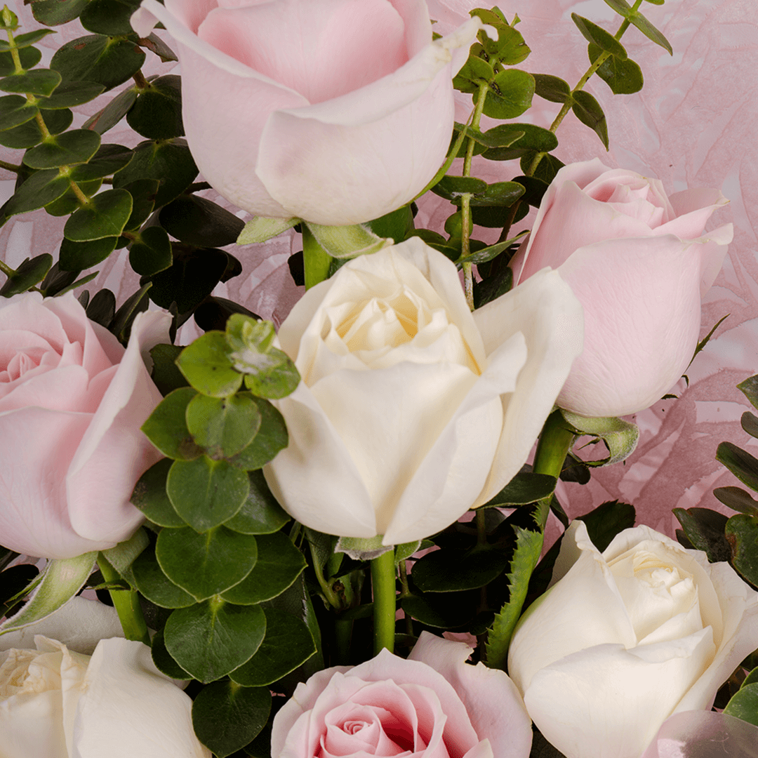 Hand -tied bouquet of pink and peach roses with eucalyptus in a pink wrap