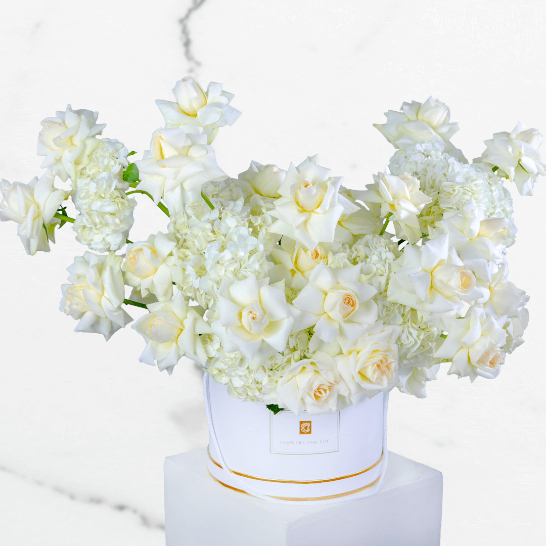 White hydrangea and rose arrangement with 30 blooms in a round white flower box.