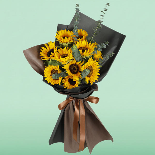Bright yellow sunflower bouquet with eucalyptus wrapped in black and brown Korean-style flower wrapping sheets