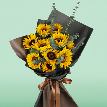 Bright yellow sunflower bouquet with eucalyptus wrapped in black and brown Korean-style flower wrapping sheets