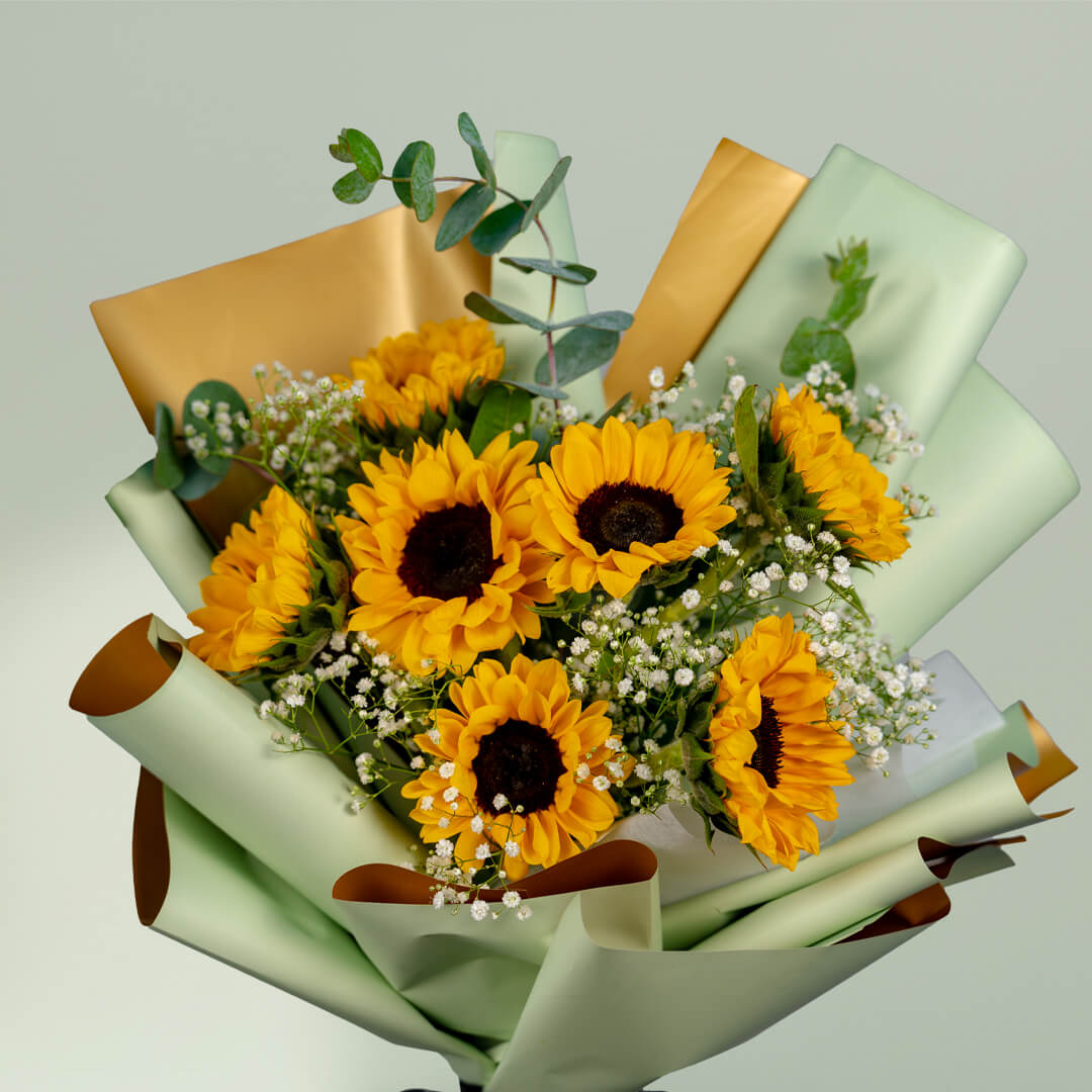 Sunflower bouquet with eucalyptus, white fillers and green wrapping tied with a black ribbon.