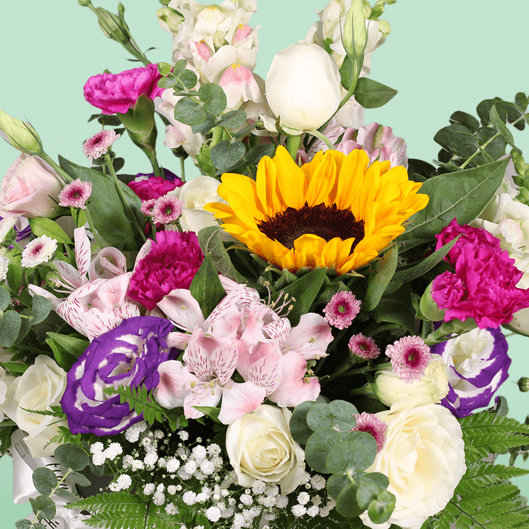 A round flower box arranged with sunflowers, roses, Eustoma, snapdragons, alstroemeria and carnations.