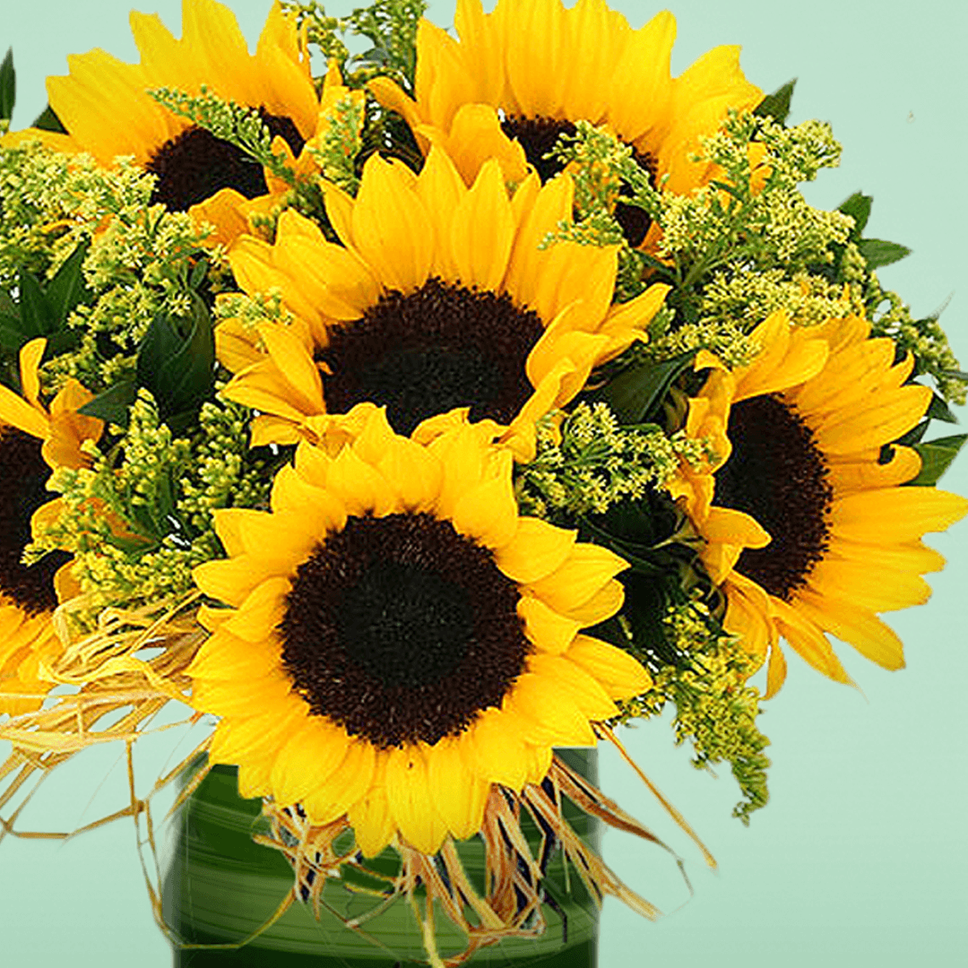 10 sunflowers and delicate fillers in a transparent glass cylinder vase.