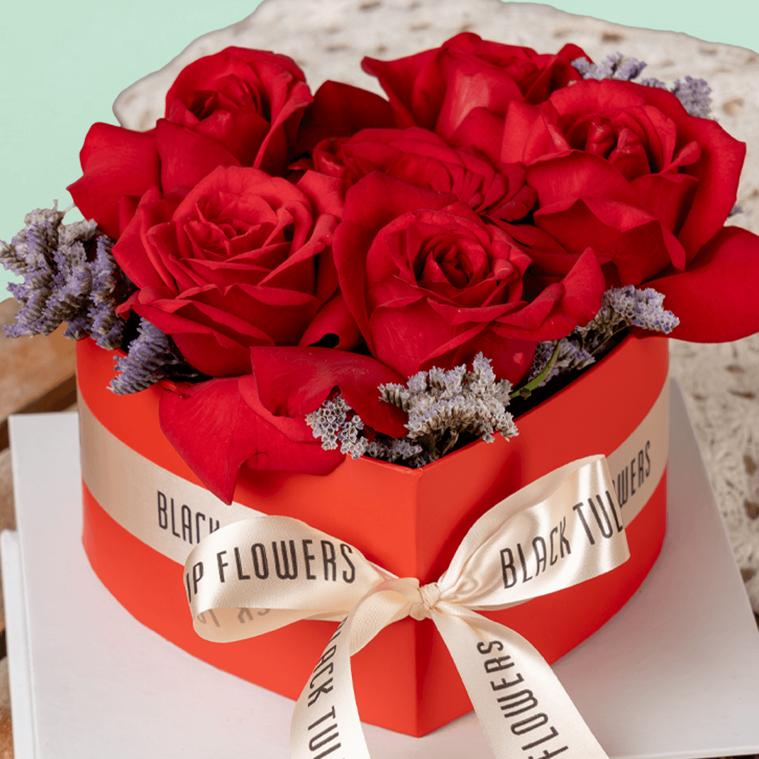 Heart-shaped red rose arrangement with Ferrero Rocher chocolates in a gift box