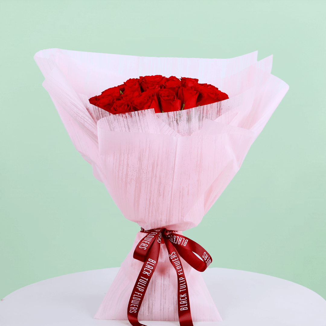 A bouquet of 40 red roses in pink wrap