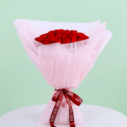 A bouquet of 40 red roses in pink wrap