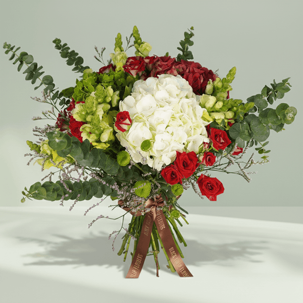 Mixed bouquet with white Hydrangeas, red Spray Roses, green Snapdragons, Limonium, Button Chrysanthemums and greenery.