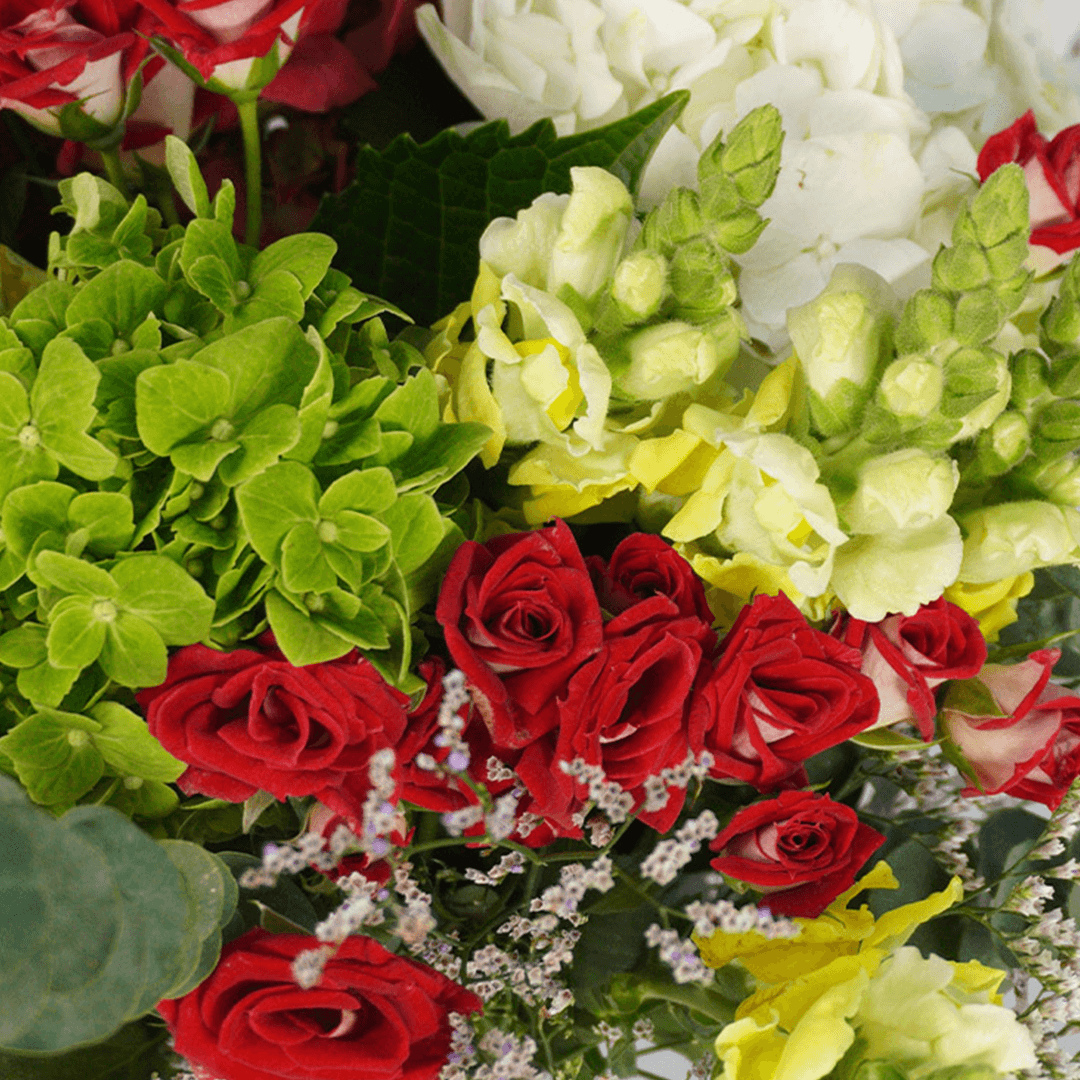 Mixed bouquet with white Hydrangeas, red Spray Roses, green Snapdragons, Limonium, Button Chrysanthemums and greenery.