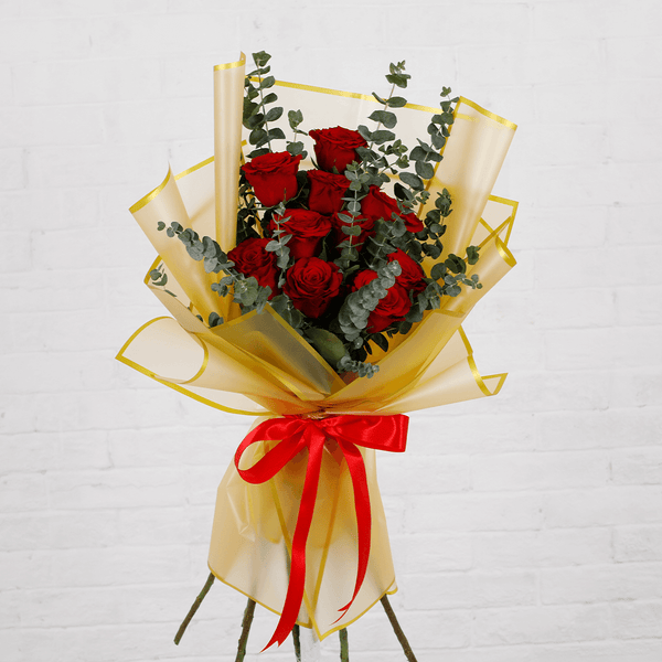 Bouquet of 10 fresh red roses with eucalyptus in a golden wrap.