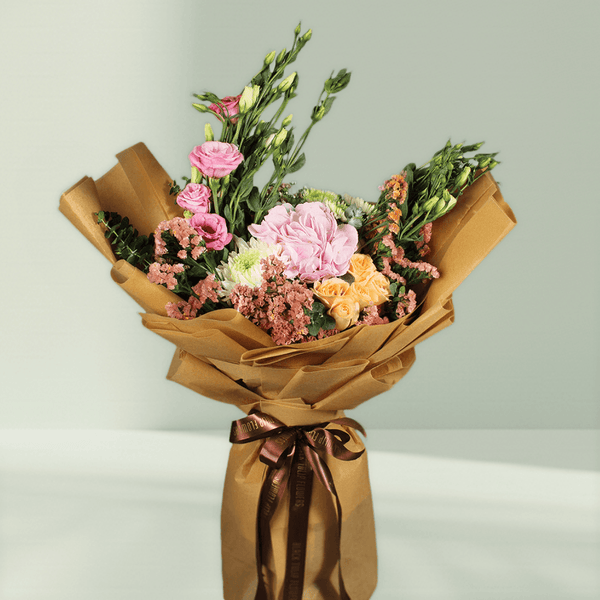 Pastel hydrangea, Eustoma, statice and chrysanthemums with greenery wrapped in rustic brown flower paper
