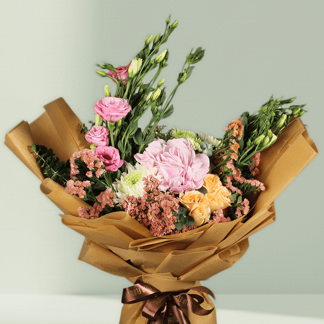 Pastel hydrangea, Eustoma, statice and chrysanthemums with greenery wrapped in rustic brown flower paper
