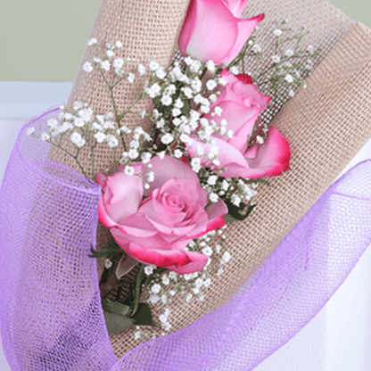 Small bouquet of three premium pink roses with baby's breath in a elegant wrap.