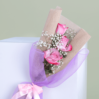 Small bouquet of three premium pink roses with baby's breath in a elegant wrap.