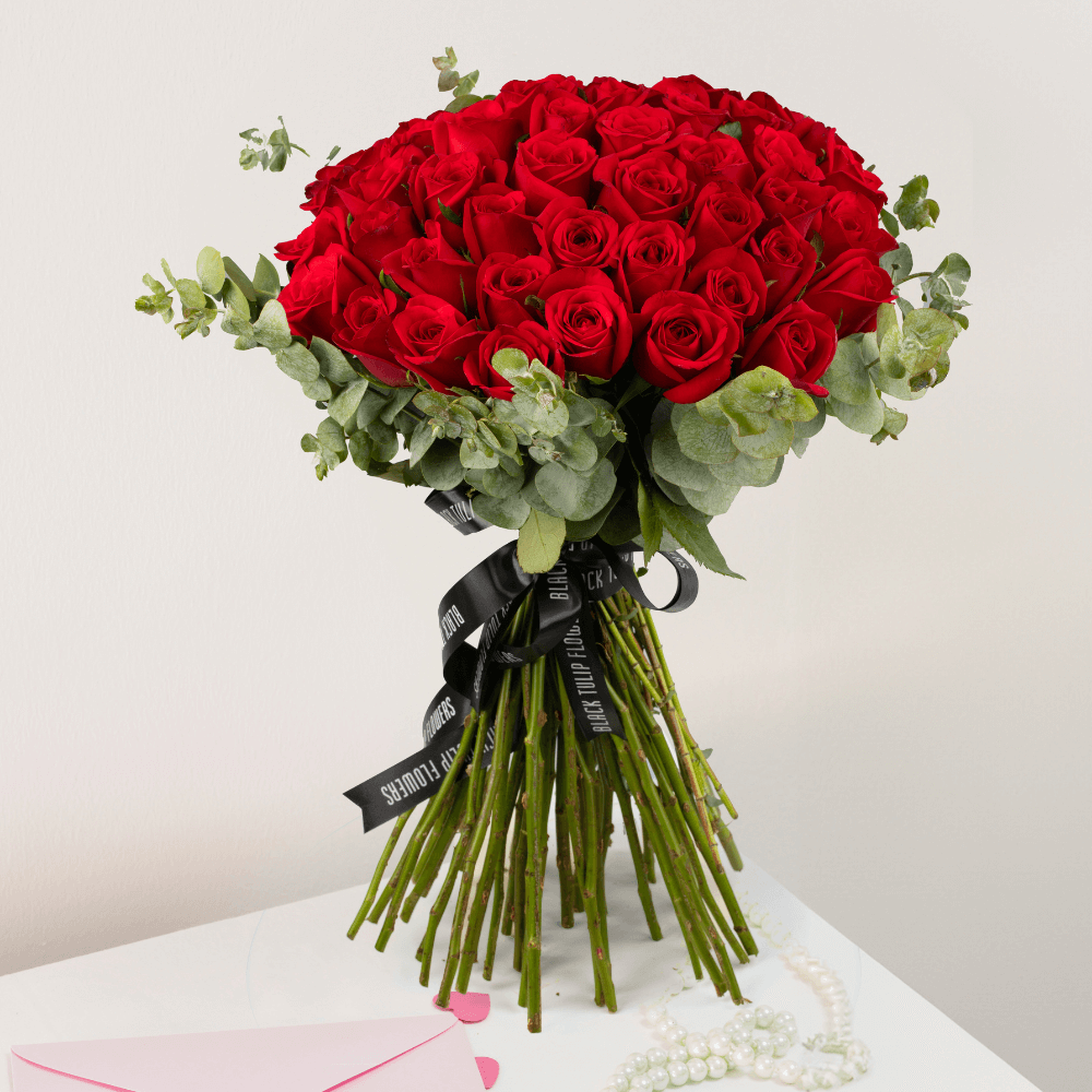Hand-tied bouquet of 50 red Roses with fresh Eucalyptus foliage.