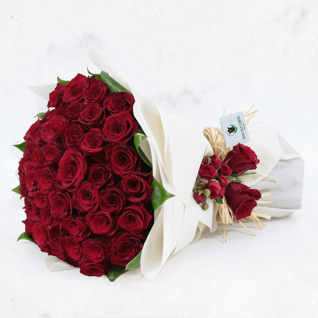 A luxury bouquet of 50 red roses in white wrap.