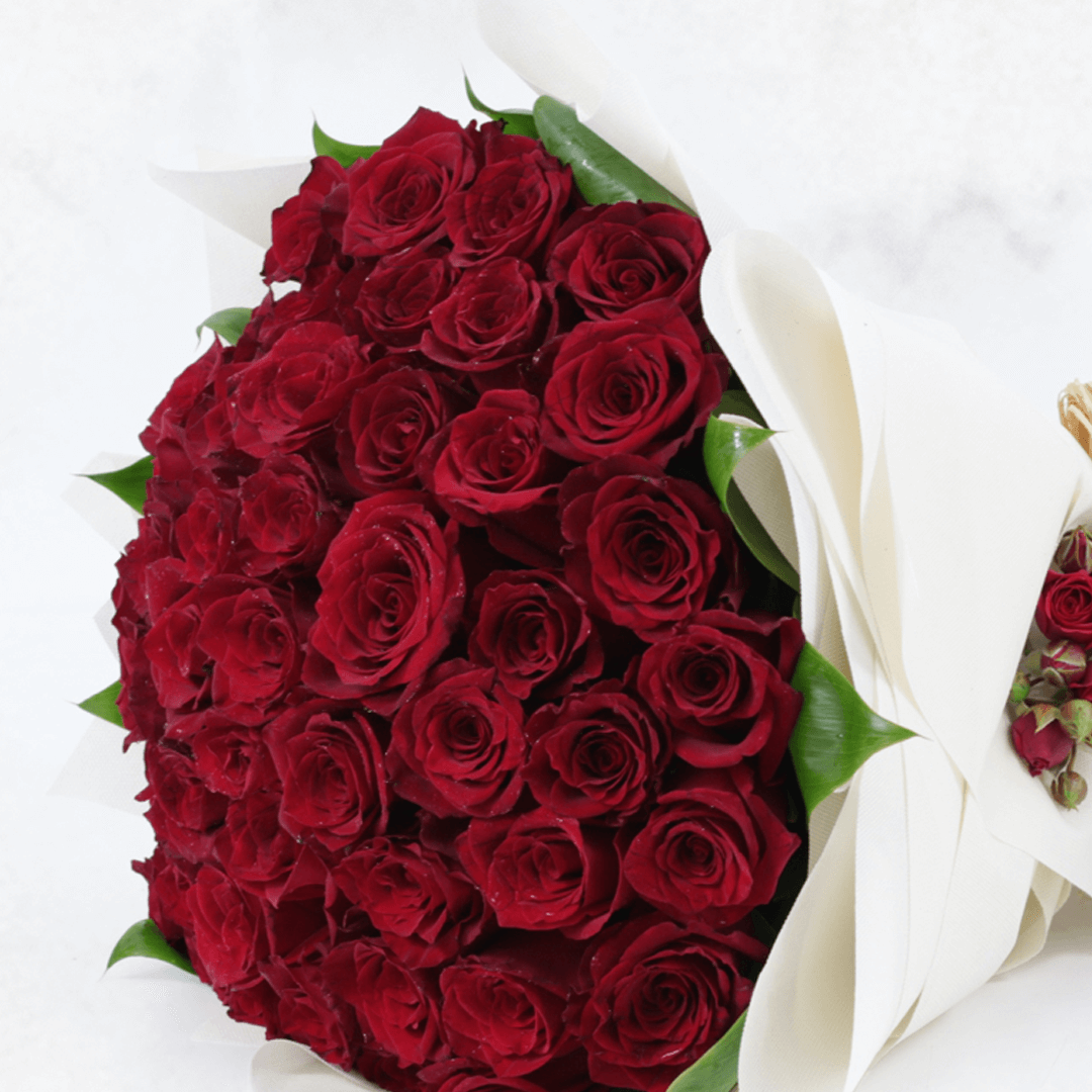 A luxury bouquet of 50 red roses in white wrap.
