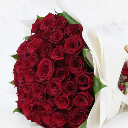 A luxury bouquet of 50 red roses in white wrap.