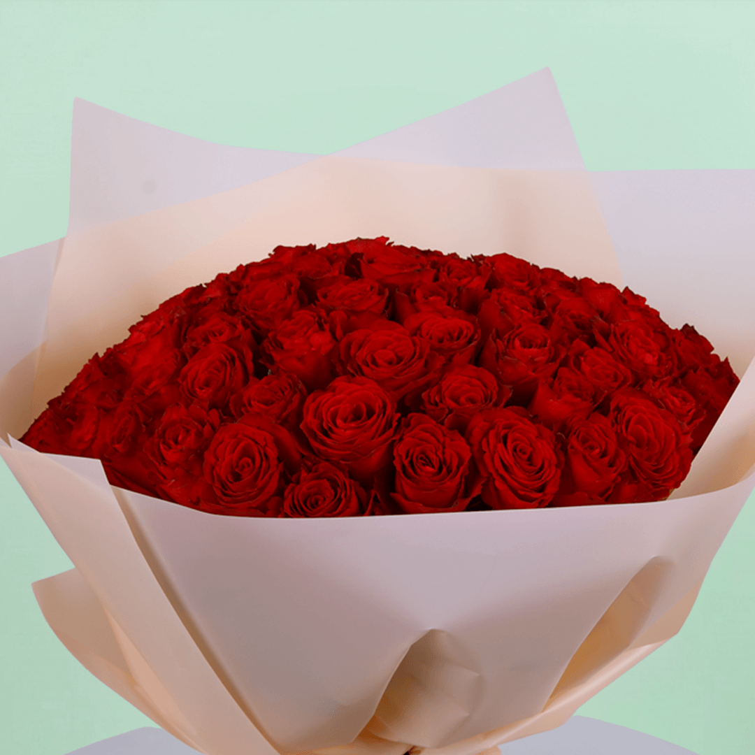 Fresh Hand-tied bouquet of 50 red roses elegantly wrapped and tied with a black ribbon.