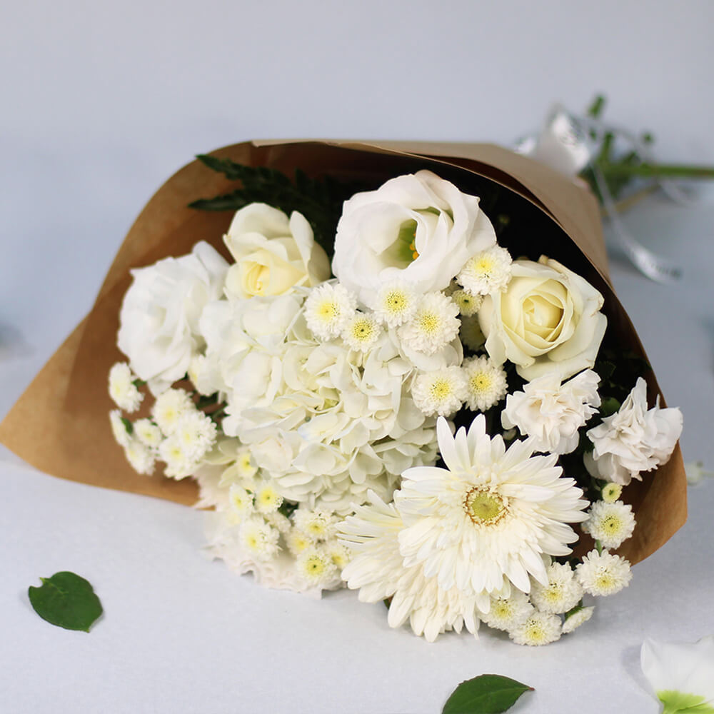 White Hydrangeas, Gerberas, Carnations and Chrysanthemums wrapped in natural-toned non-woven paper.