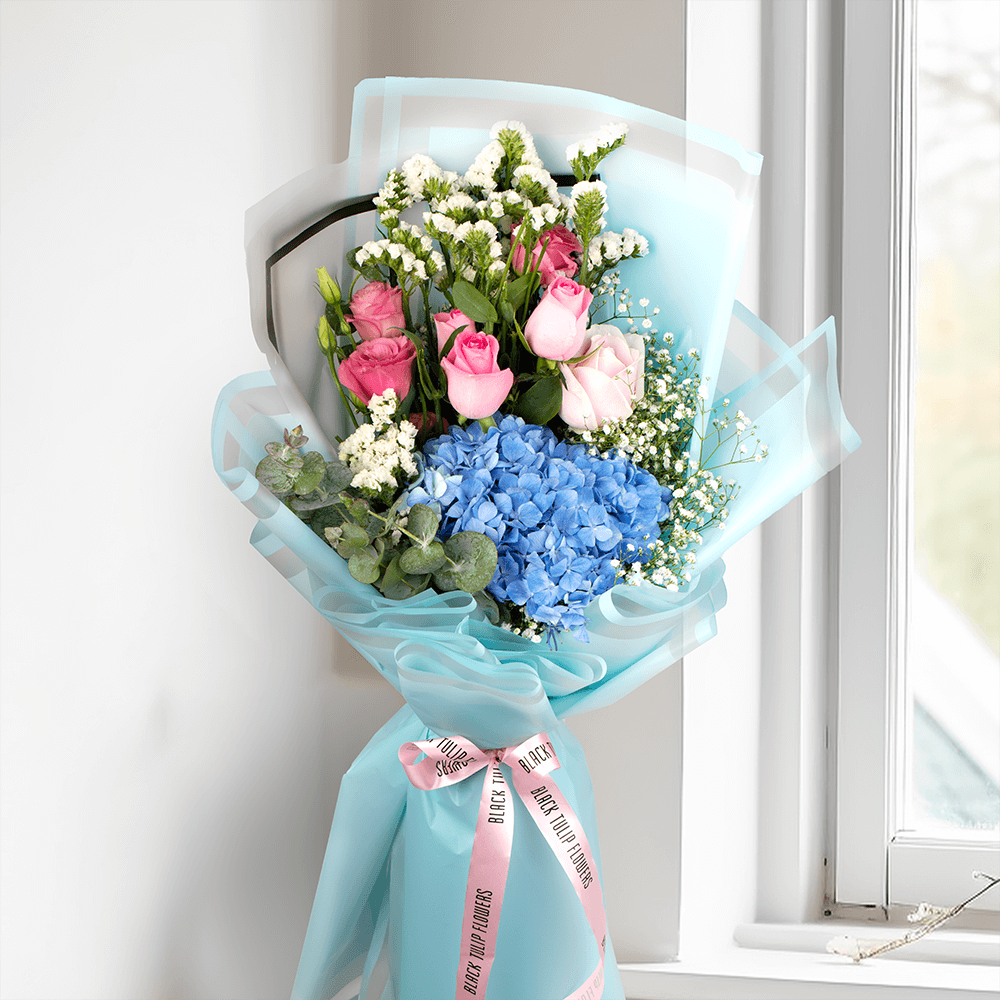 Pastel blue Hydrangea bouquet with pink Roses, Eustoma, Statice and white Gypsophila in Korean-style blue wrapping.