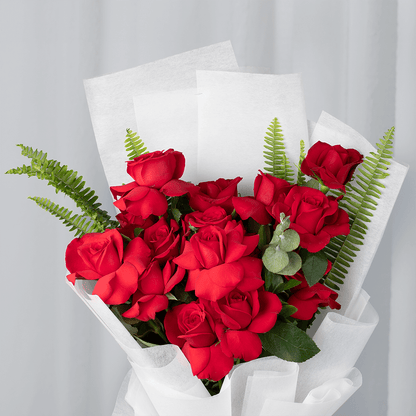Bouquet of 20 red Roses with Eucalyptus and green Ferns wrapped in white non-woven paper.