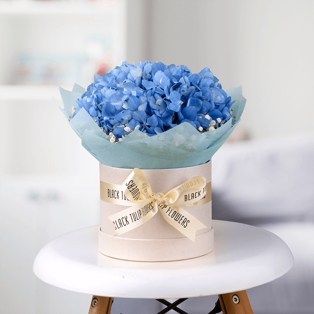 Blue Hydrangea and white Gypsophila arranged in an elegant flower box.