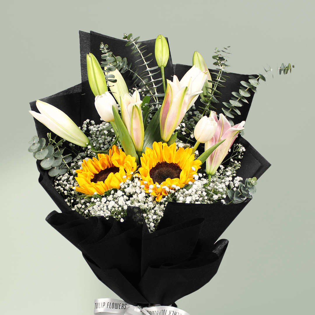 Sunflower and white lily bouquet with baby’s breath, greenery and stylish black wrapping.