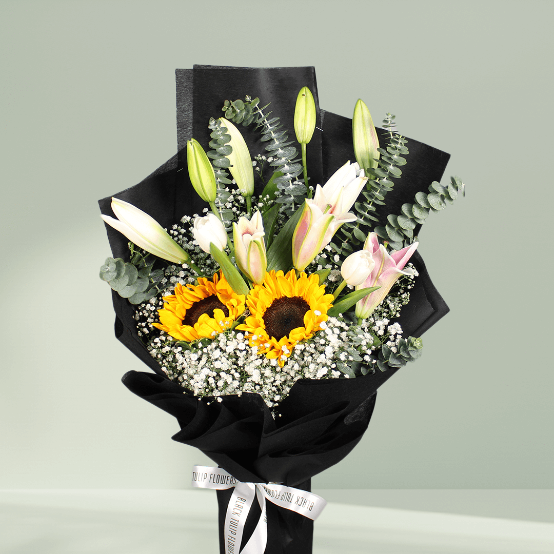 Sunflower and white lily bouquet with baby’s breath, greenery and stylish black wrapping.