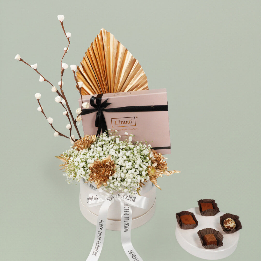 A festive Diwali flower box featuring white chrysanthemums, dry flowers and chocolates