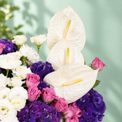 Mixed flowers featuring hydrangea, eustoma, roses and dried amaranthus in a vase