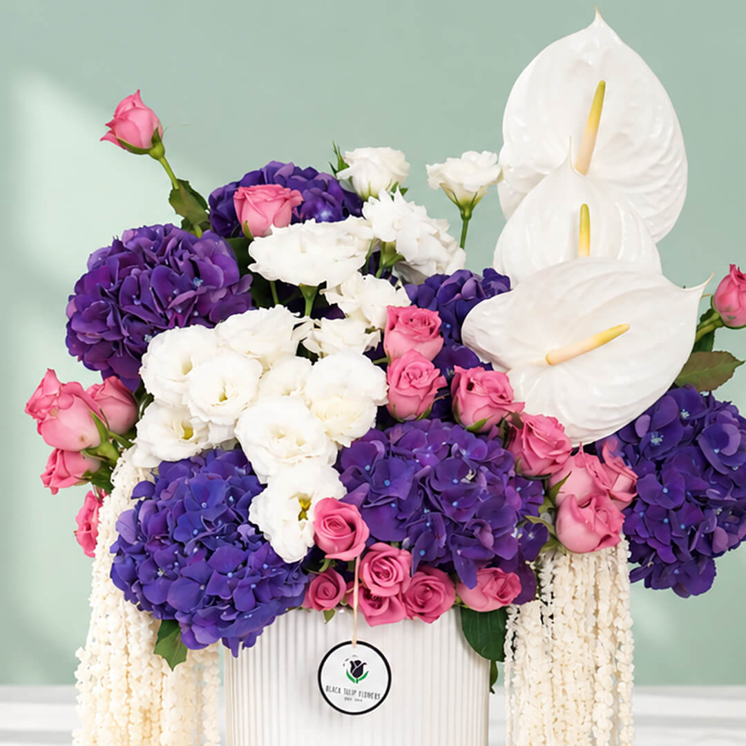 Mixed flowers featuring hydrangea, eustoma, roses and dried amaranthus in a vase