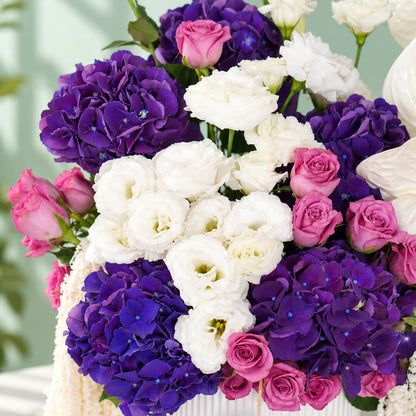 Mixed flowers featuring hydrangea, eustoma, roses and dried amaranthus in a vase