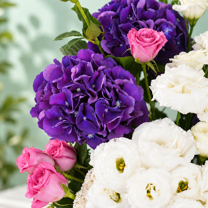 Mixed flowers featuring hydrangea, eustoma, roses and dried amaranthus in a vase