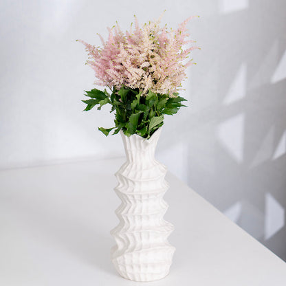 Fresh Astilbe cut flowers neatly arranged in brown paper wrapping