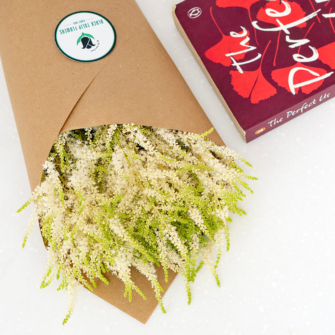 Fresh Astilbe cut flowers neatly arranged in brown paper wrapping