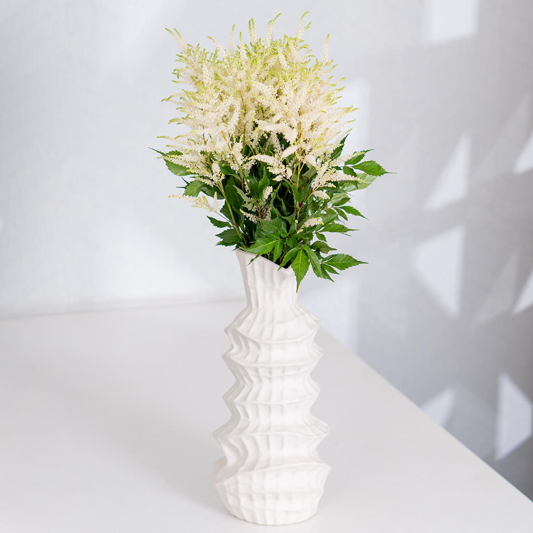 Fresh Astilbe cut flowers neatly arranged in brown paper wrapping