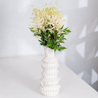 Fresh Astilbe cut flowers neatly arranged in brown paper wrapping
