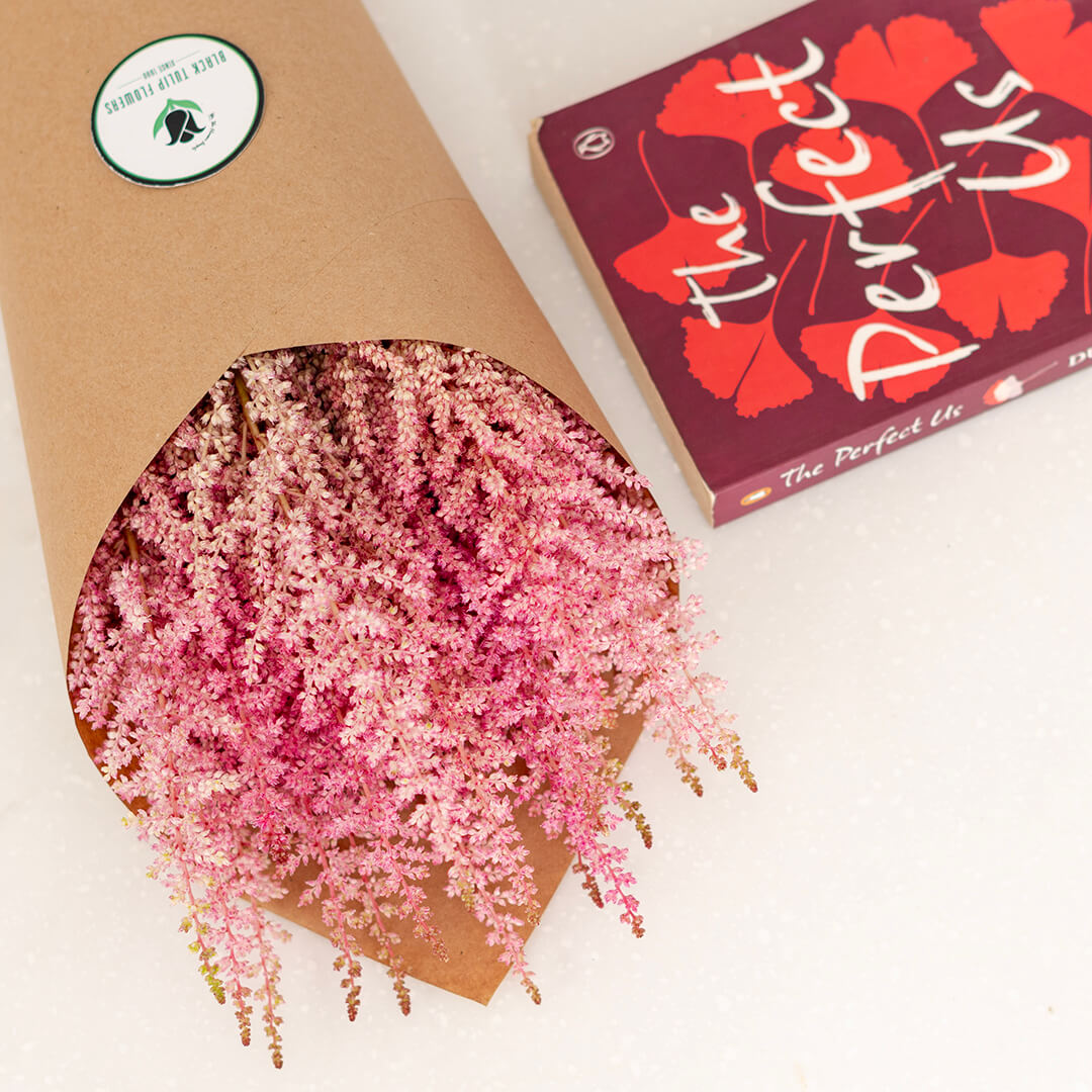 Fresh Astilbe cut flowers neatly arranged in brown paper wrapping