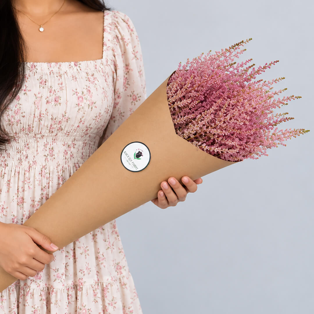 Fresh Astilbe cut flowers neatly arranged in brown paper wrapping
