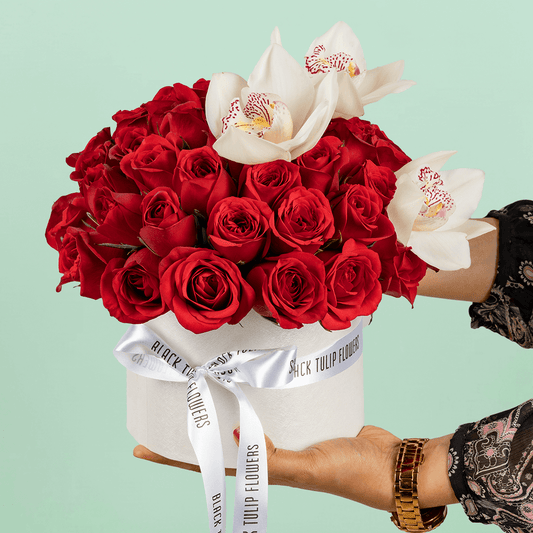 50 Red Roses & White Orchid Box arranged with 50 red roses, white cymbidium orchids and fresh foliage