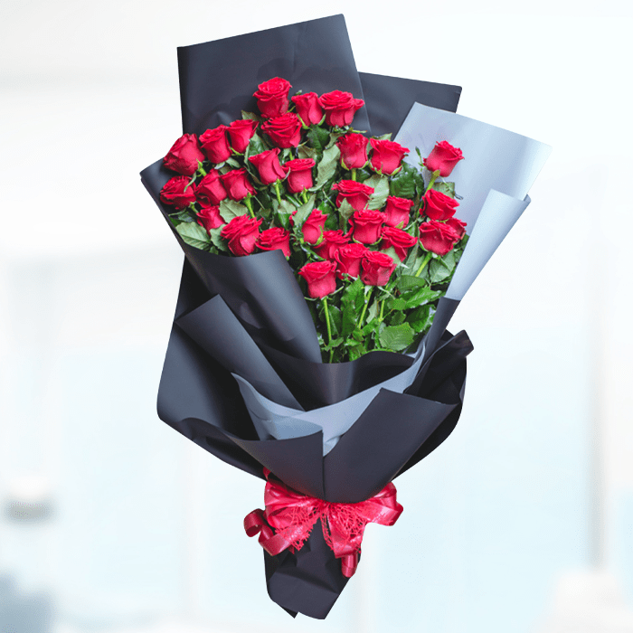 A bouquet of 30 red roses wrapped in layered black and grey non-woven paper