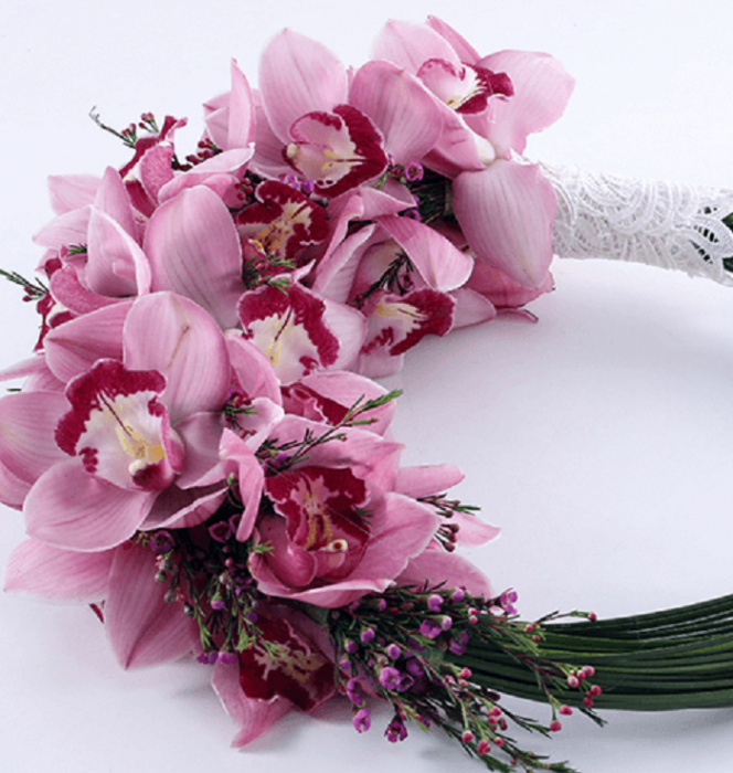 A loop-style bridal bouquet featuring pink Cymbidium orchids and delicate accent flowers in finished with a white lace handle.